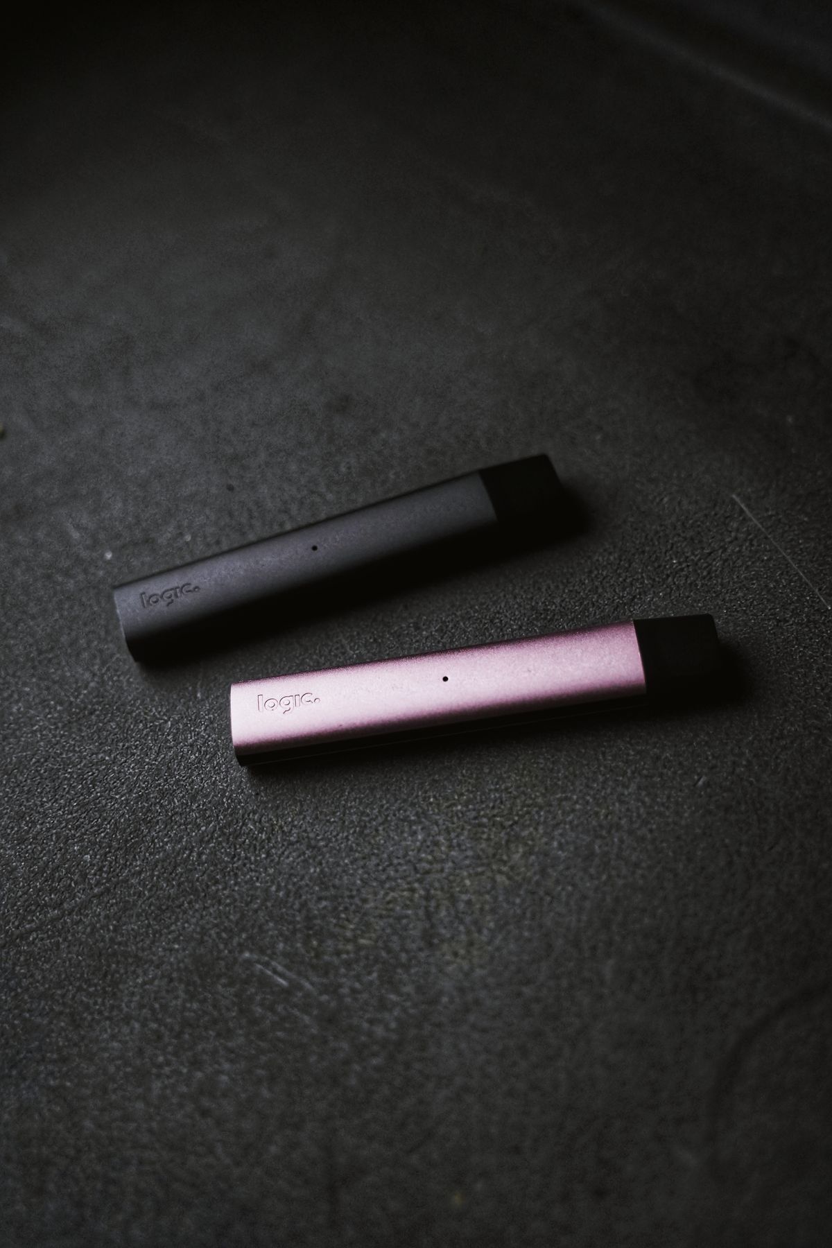 Zwei schlanke Vape-Geräte in Pink und Schwarz