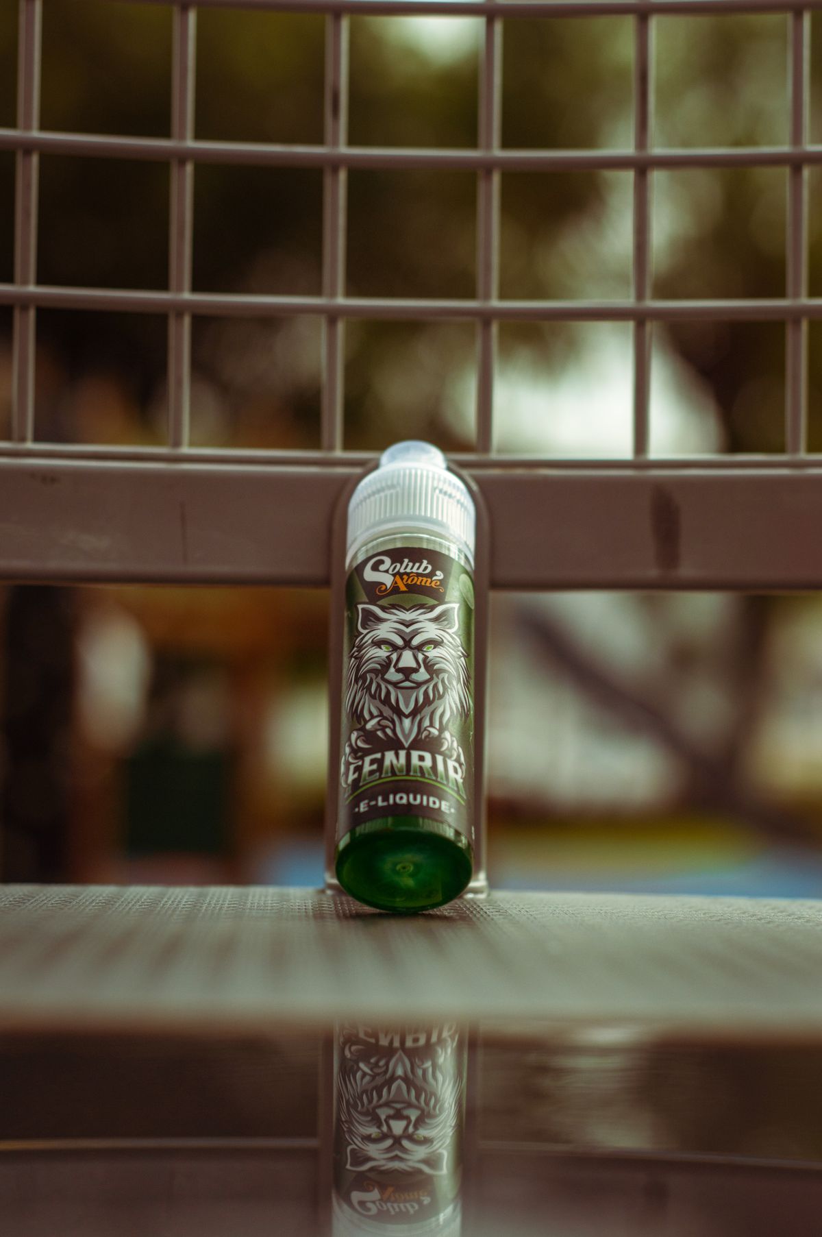 Grüne Liquid-Flasche auf einer Bank im Freien