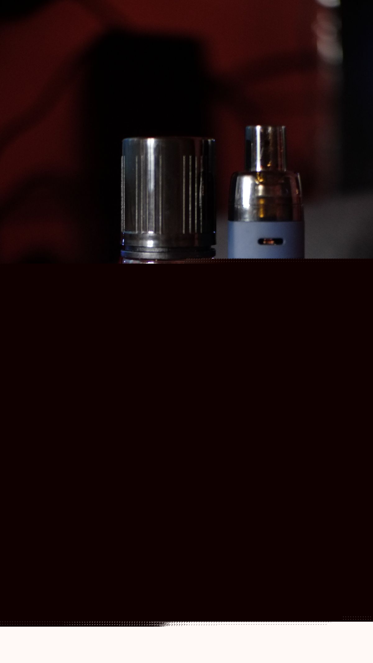 Liquid-Flasche und Vape-Gerät auf einem Holztisch