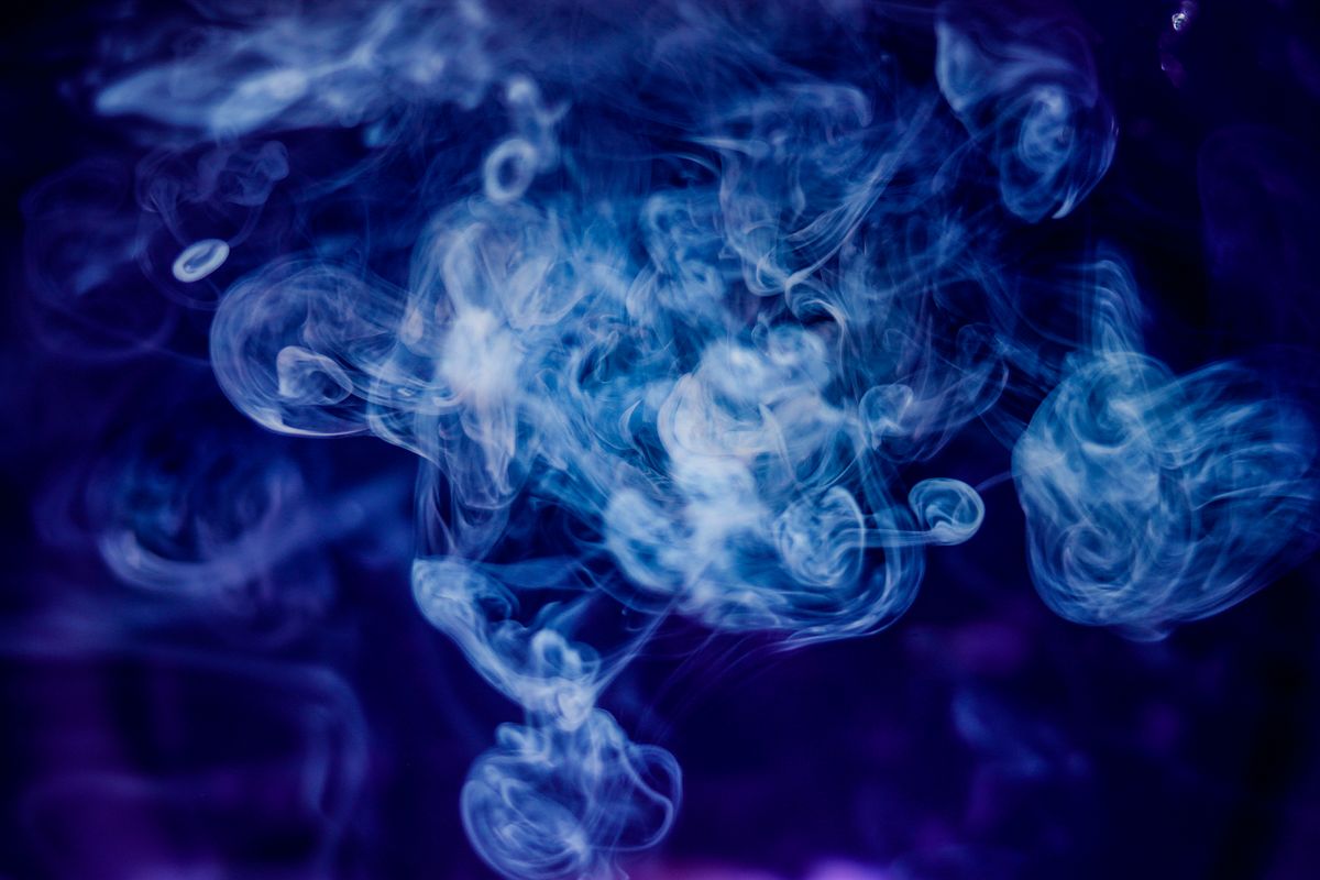 Verschlungenes blaues Rauchmuster vor dunkelblauem Hintergrund