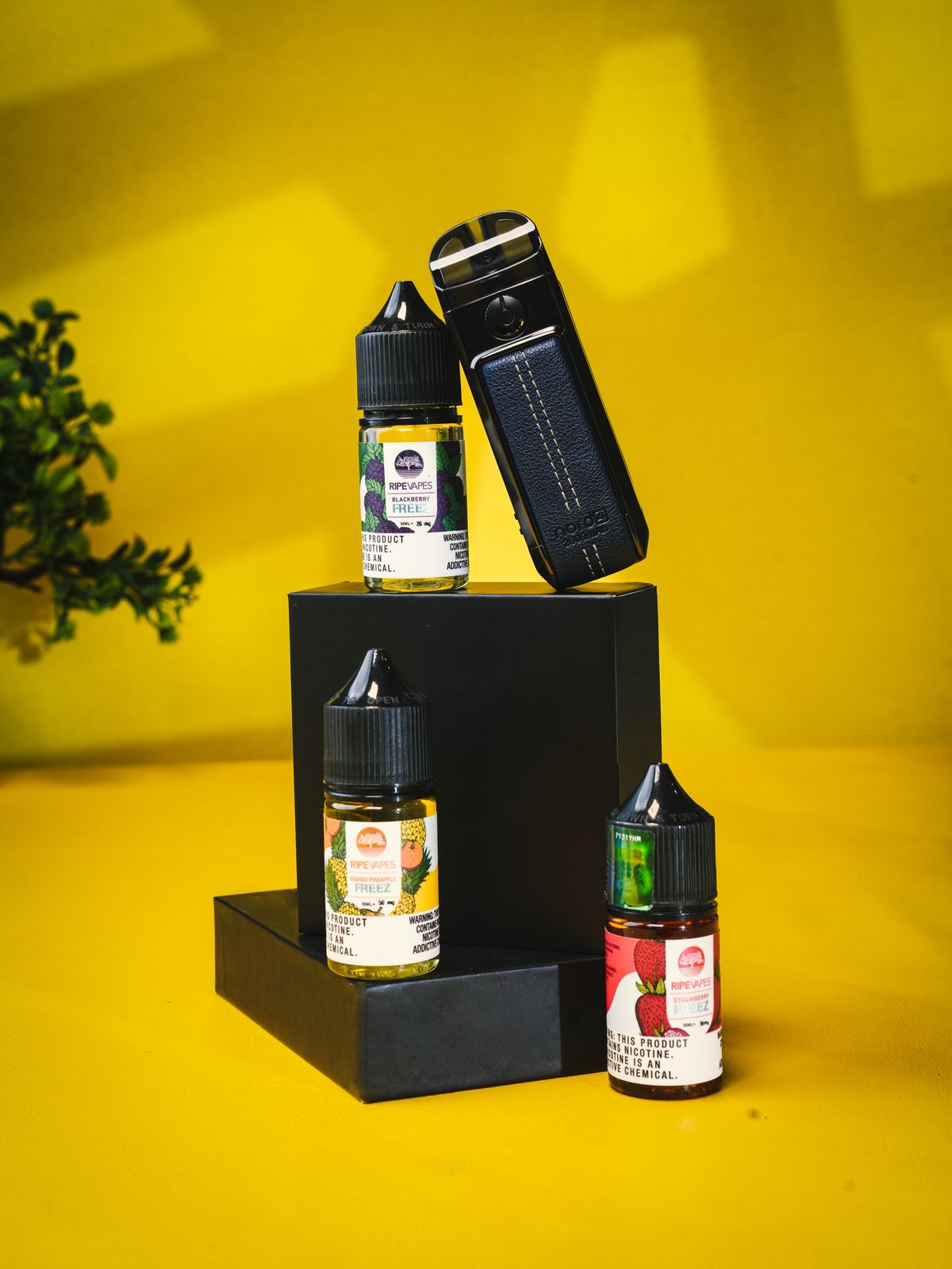 Vape-Gerät und Liquid-Flaschen vor leuchtend gelbem Hintergrund
